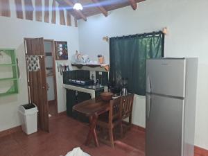 诺萨拉Casa Rosada Nosara的厨房配有木桌和冰箱。
