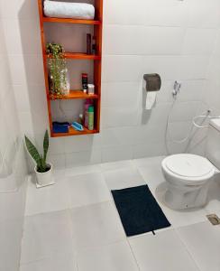 达累斯萨拉姆Sally's home-near JNIA airport的白色的浴室设有卫生间和架子。