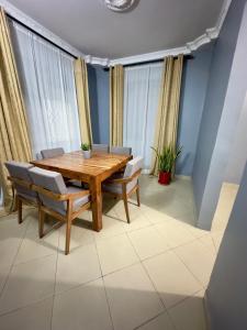 达累斯萨拉姆Sally's home-near JNIA airport的一间带木桌和椅子的用餐室