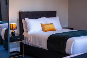 悉尼贝斯沃特精品旅馆 的一间卧室配有一张带橙色枕头的床