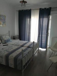 BasarabiTina Guest House的一间卧室配有一张带蓝色窗帘的大床