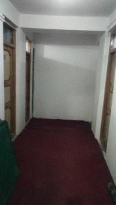 卡尔吉尔OYO Holidayinn的一间空房间,铺有红色地毯,设有窗户
