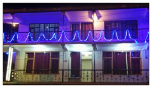 卡尔吉尔OYO Holidayinn的阳台上带有蓝色 ⁇ 虹灯标志的建筑