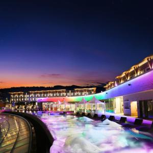 西归浦市Shinhwa Jeju Shinhwa World Hotels的夜间带游泳池的度假村