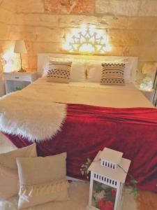 莱切Palazzo Emy的一间卧室配有一张大床,提供红色毯子和枕头