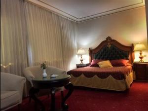 安卡拉DOGA RESIDENCE HOTEL Ankara的一间卧室配有一张床、一把椅子和一张桌子