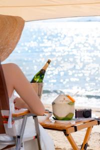 三亚金茂三亚亚龙湾丽思卡尔顿酒店的坐在桌子旁的椅子上的女人,带一瓶香槟