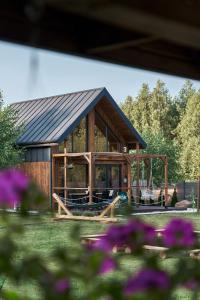 JoniecOsada Joniec的小木屋,设有黑色屋顶和紫色的鲜花