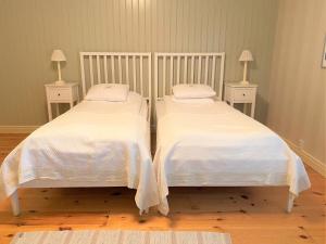 谢莱夫特奥Stiftsgården Konferens & Hotell的客房内的两张床、白色的毯子和枕头