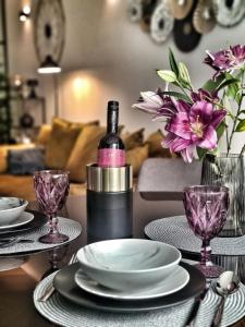 瓦拉日丁BNF Lounge的一张桌子,上面放有盘子,一瓶葡萄酒和鲜花