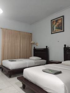 吉利马努克莱斯塔里酒店的酒店客房设有三张床和窗户。