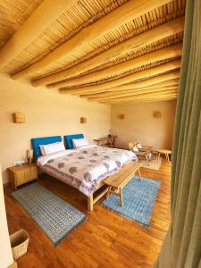 列城The Indus River Camp的一间卧室设有一张床和木制天花板