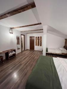 阿尔杰什河畔库尔泰亚Barlogul din Vidraru的配有一张床和一张书桌的大房间