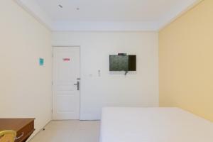 泗水Urbanview Erga Family Residence Syariah Surabaya的一间白色的卧室,配有床和门