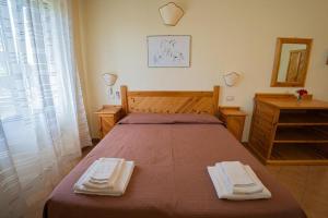 安圭拉萨巴齐亚阿贵托瑞斯莫祖嘎勒利酒店的一间卧室配有一张床,上面有两条毛巾