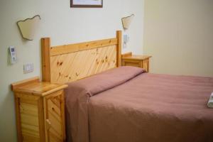 安圭拉萨巴齐亚阿贵托瑞斯莫祖嘎勒利酒店的一间卧室配有一张带木制床头板的床