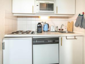 DoucyT Du Morel - A25 - 4 PERS的厨房配有白色橱柜和炉灶烤箱。