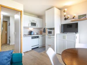 DoucyT Du Morel - A25 - 4 PERS的小厨房配有白色橱柜和桌子