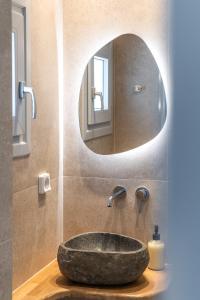 纳克索乔拉Disis Residence的一间带石制水槽和镜子的浴室
