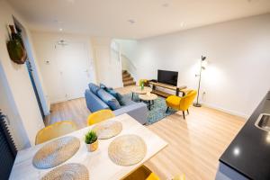 蒂尔Friendly 50m2 One-Bedroom Apartment的客厅配有蓝色的沙发和黄色的椅子