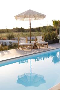 布拉卡OLIVES seaside villas (4elies)的游泳池旁的野餐桌和遮阳伞