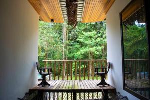Kampung Sunjai GapoiZen Forest Entire Villa with Private Pool at Karak的门廊配有两把椅子和大窗户
