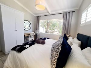 滨海肯顿Victoria's Secret的卧室配有带枕头的床铺和窗户。