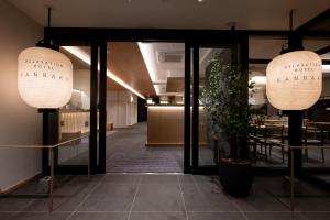 秋田Hotel KAN-RAKU Akita Kawabata的大堂设有2盏大灯和桌子