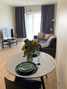 塔尔图Haki Apartment的客厅配有带向日葵花瓶的桌子