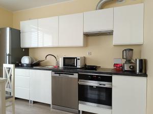 奥瓦瓦Apartament Rodzinny的厨房配有白色橱柜和微波炉