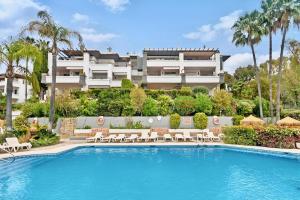 贝纳阿维斯El Lago de Los Arqueros 2 bedrooms penthouse en Benahavis的大楼前设有游泳池的酒店