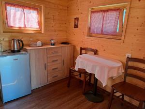 SlivnaFarm Stay Pr Lavric的小屋内的厨房配有桌子和冰箱