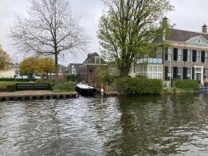 沃尔堡Tuinhuis aan het water的一条河,河上有房子和船
