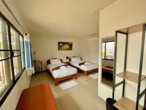 清莱บ้านกาญจน์ เชียงราย Baan Kan Chiang Rai的带两张床和镜子的客房