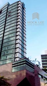 古晋Hock Lee Hotel & Residences的一座高大的建筑,上面有玻璃窗