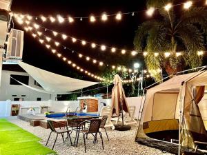 马六甲Klebang Melaka Private Pool 12pax-4BR-Sing K-Coway的庭院设有帐篷和桌椅