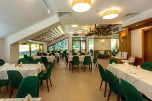 波罗维茨Musala Hotel的用餐室配有白色的桌子和绿色的椅子