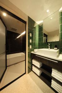 高山FAV LUX Hida Takayama的带浴缸、水槽和镜子的浴室