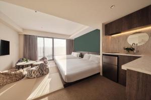 高山FAV LUX Hida Takayama的酒店客房,配有床和镜子