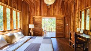 帕干岛Baan Bhuwann Forest Chalet的卧室配有一张床、一张书桌和窗户。