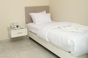 十月六日城Dream House的一间卧室配有白色床单和床头柜。