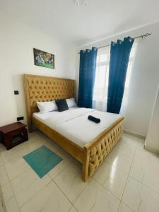 KiambuOmuts one bed airbnb with swimmingpool的一间卧室配有一张带蓝色窗帘的大床