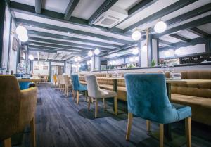 里摩日Kyriad Limoges Centre Gare - Atrium的一间设有蓝色椅子的餐厅和一间长长的酒吧