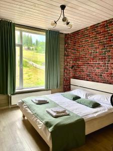 布克维Friends house bukovel的一间卧室设有一张带砖墙的大床