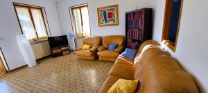 AndrateCasa in montagna con giardino privato recintato的客厅配有沙发和两把椅子