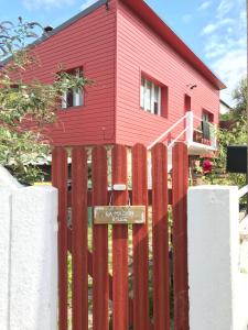 滨海图维列La Maison Rouge的红色房子前面的木栅栏