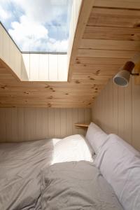 巴拉特Enchanting Tiny House with wood burner and hot tub in Cairngorms的一张位于带大窗户的房间内的床铺