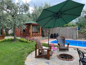 İznikTiny House Village的一个带两把椅子和绿伞的庭院