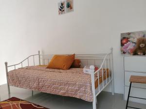 日惹Ambarukmo Green Hill / MA 8的卧室配有带橙色枕头的白色床