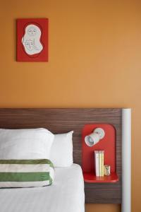 戛纳艾博利亚酒店的一间卧室配有一张红色床头板的床